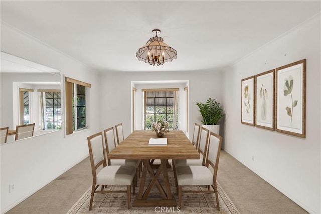 dining room with light carpet and an inviting chandelier