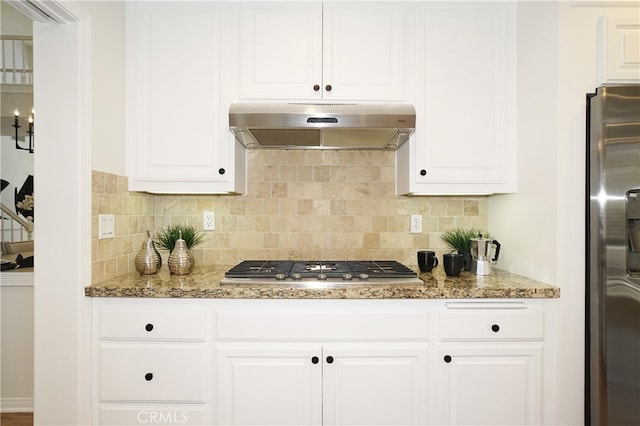 kitchen with stainless steel appliances, backsplash, stone countertops, and white cabinetry