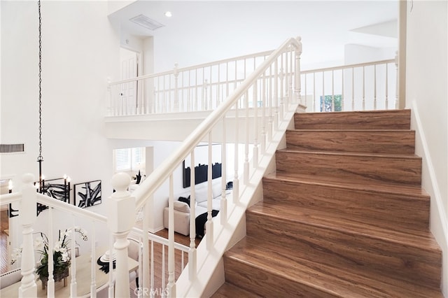 stairs featuring a chandelier