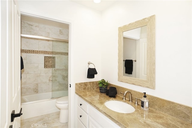 full bathroom featuring vanity, tile patterned flooring, toilet, and combined bath / shower with glass door