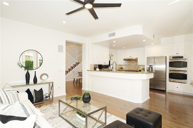 living room with ceiling fan, hardwood / wood-style flooring, and sink