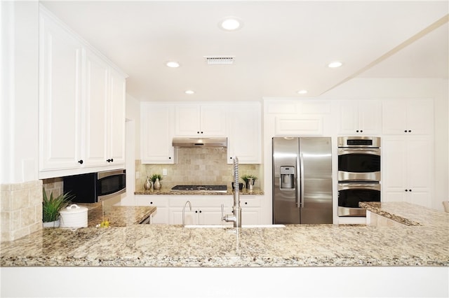 kitchen featuring backsplash, white cabinetry, light stone countertops, and stainless steel appliances