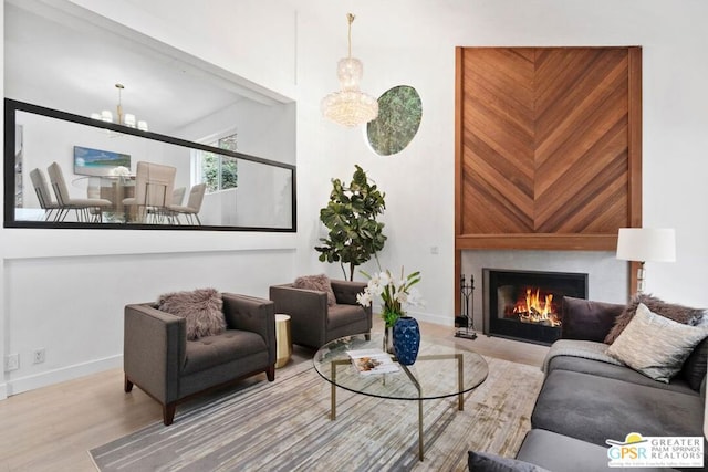 living room with an inviting chandelier and light wood-type flooring