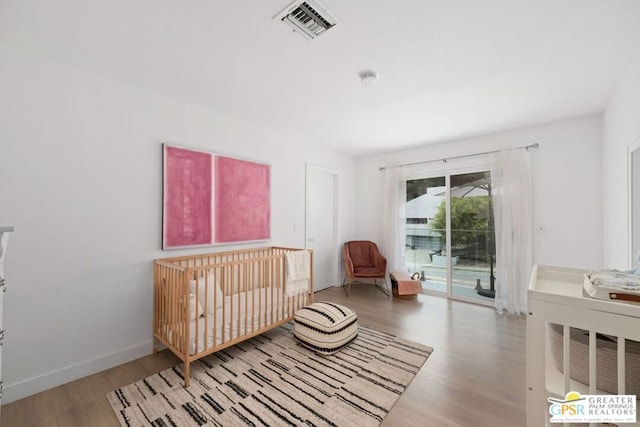 bedroom with access to outside and light hardwood / wood-style flooring