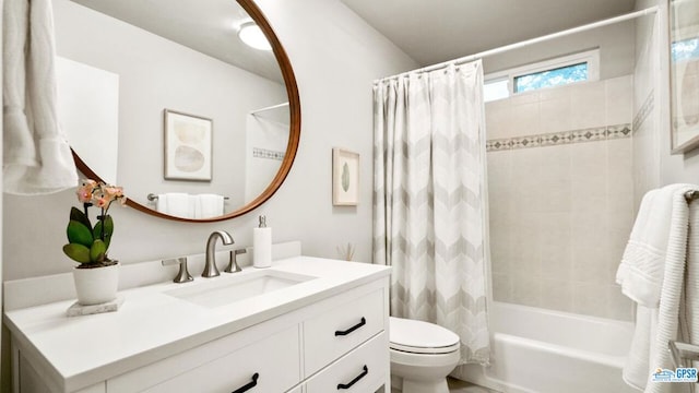 full bathroom with vanity, shower / bath combo with shower curtain, and toilet