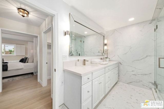 bathroom featuring walk in shower, vanity, and wood-type flooring