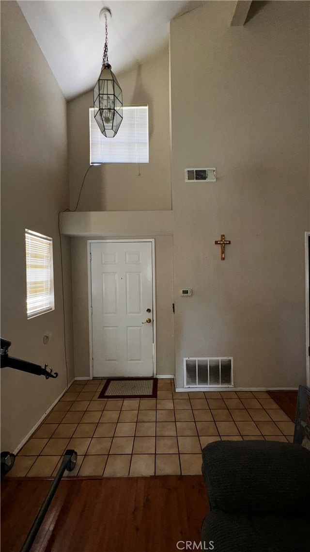 tiled entryway featuring high vaulted ceiling