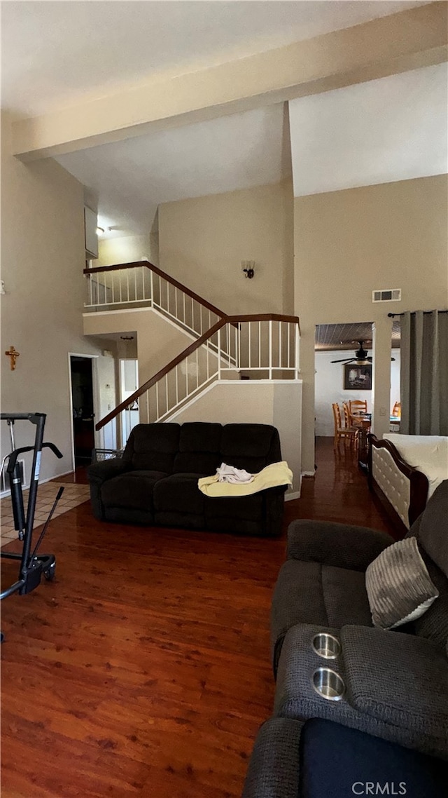 living room featuring a high ceiling, beam ceiling, and dark hardwood / wood-style floors