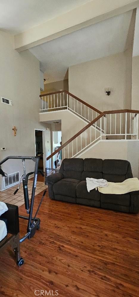 living room with high vaulted ceiling, beam ceiling, and hardwood / wood-style flooring