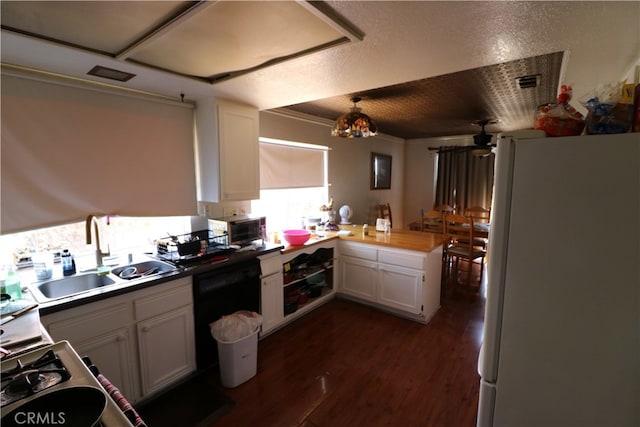 kitchen featuring white cabinets, white refrigerator, and a textured ceiling