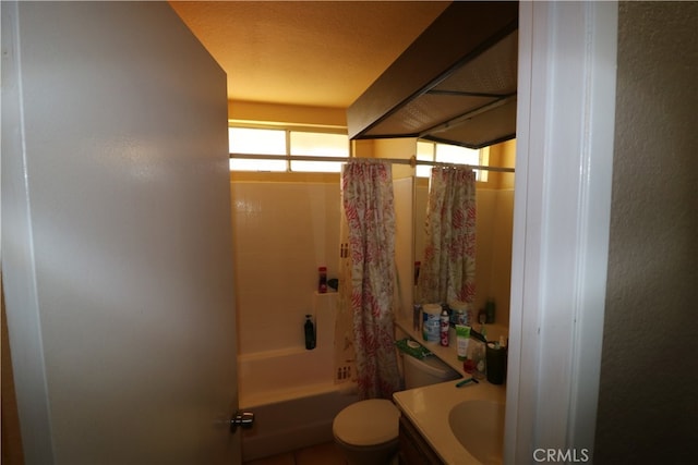 full bathroom featuring shower / bath combo with shower curtain, a textured ceiling, vanity, and toilet