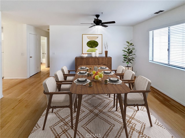 dining area with ceiling fan and light hardwood / wood-style flooring