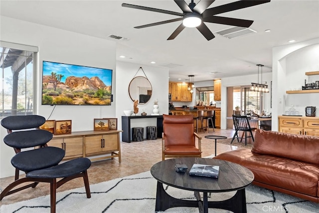 living room with ceiling fan with notable chandelier