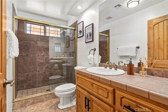 bathroom featuring vanity, toilet, tile patterned floors, and a shower with door