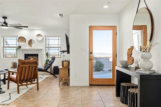 foyer featuring light tile patterned floors and ceiling fan