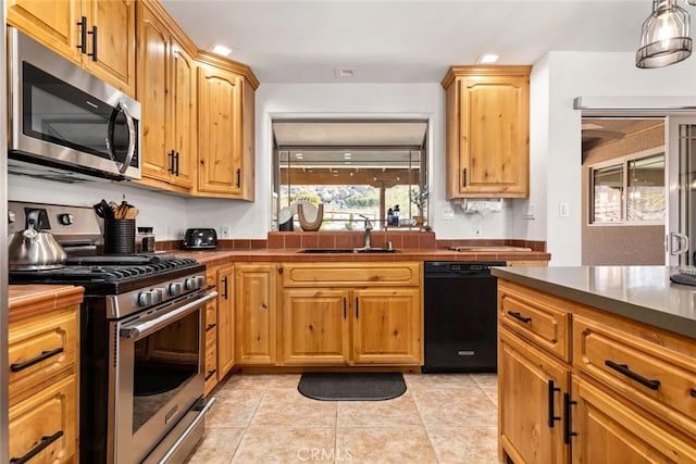 kitchen featuring stainless steel appliances, sink, and light tile patterned flooring