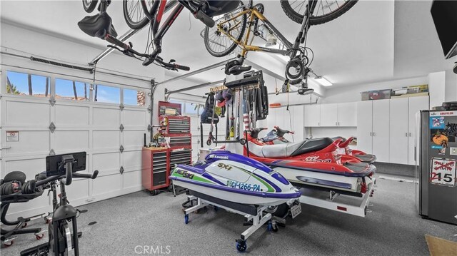 garage featuring stainless steel refrigerator and a garage door opener