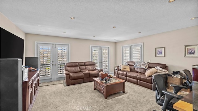 living room featuring light colored carpet, a textured ceiling, and french doors