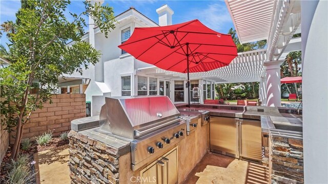 view of patio with a pergola and area for grilling