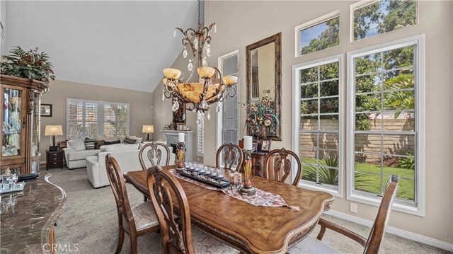 carpeted dining space featuring high vaulted ceiling and a chandelier