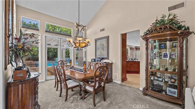 carpeted dining space with high vaulted ceiling and a notable chandelier