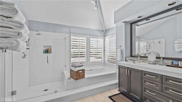 bathroom with vanity, lofted ceiling, and independent shower and bath