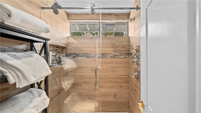 bathroom with wood walls and walk in shower