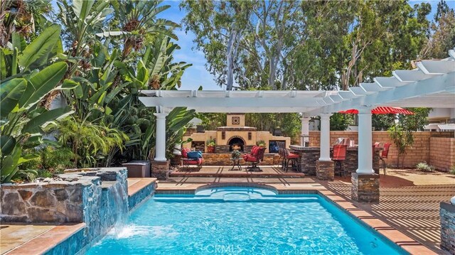 view of pool with an outdoor fireplace, a pergola, pool water feature, a bar, and a patio