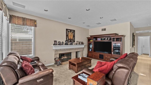 living room featuring a fireplace and light colored carpet