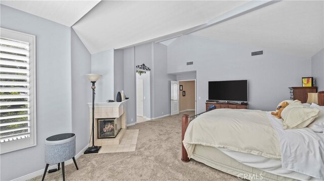 bedroom featuring a fireplace, light colored carpet, and vaulted ceiling