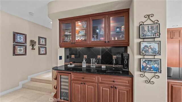 bar with sink, beverage cooler, dark stone counters, decorative backsplash, and light tile patterned flooring