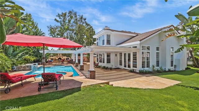 rear view of property with a yard, a pergola, pool water feature, and a patio area