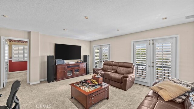 living room featuring light carpet, french doors, and a textured ceiling