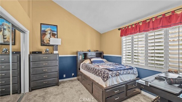 carpeted bedroom with lofted ceiling