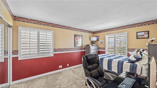 bedroom featuring light colored carpet and a textured ceiling