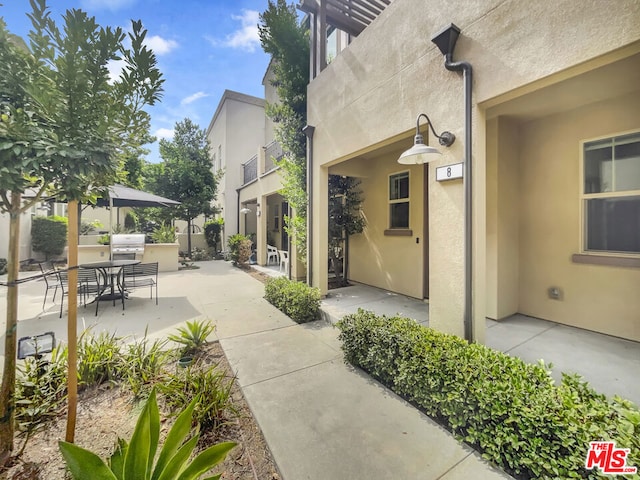 view of patio / terrace with grilling area, a balcony, and exterior kitchen