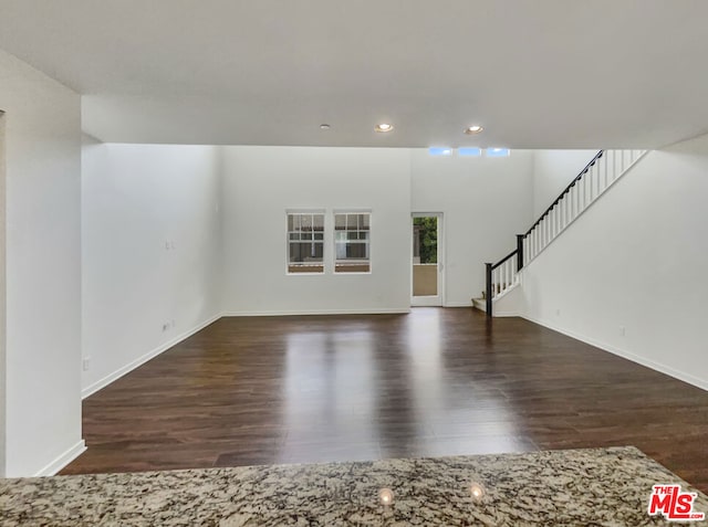 unfurnished living room with dark wood-type flooring