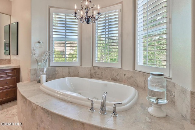 bathroom with tile patterned flooring, vanity, a relaxing tiled tub, and an inviting chandelier