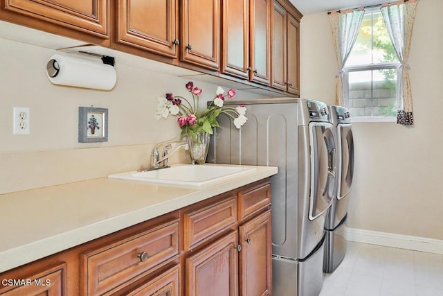 laundry room with cabinets, independent washer and dryer, and sink