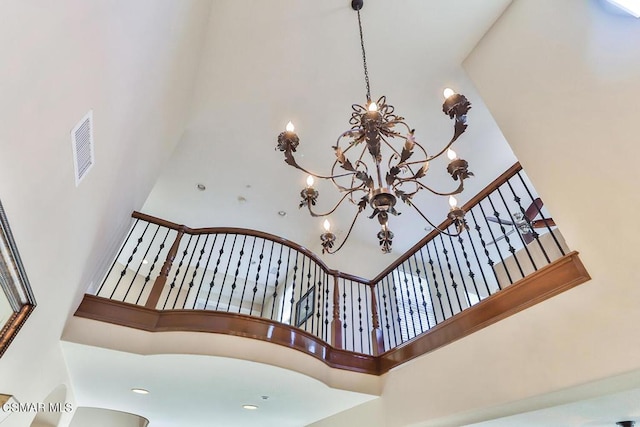 staircase with a chandelier and a high ceiling