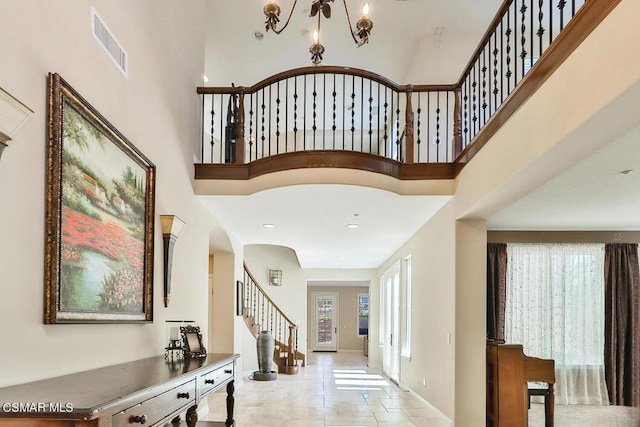 entrance foyer featuring a towering ceiling and a chandelier