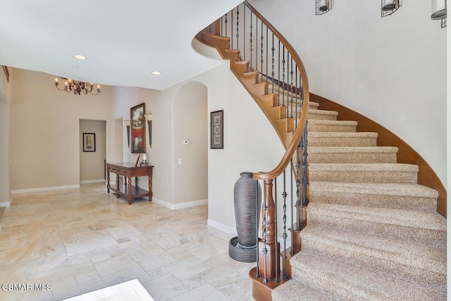 staircase featuring a notable chandelier