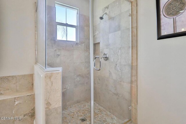 bathroom featuring a shower with shower door