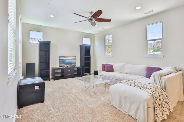 living room featuring a wealth of natural light, carpet, and ceiling fan