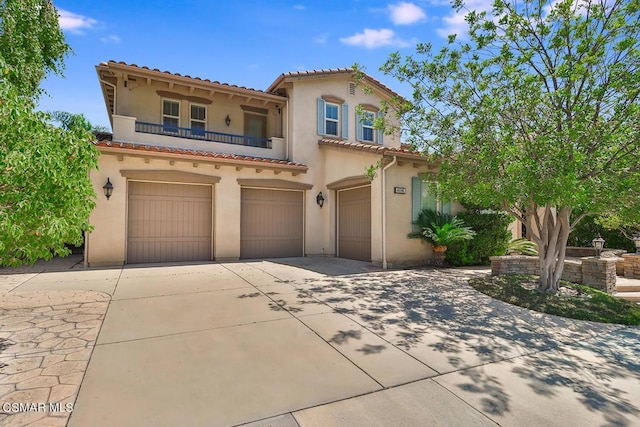 mediterranean / spanish-style home featuring a balcony and a garage