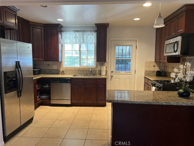 kitchen with stainless steel appliances, backsplash, decorative light fixtures, and sink