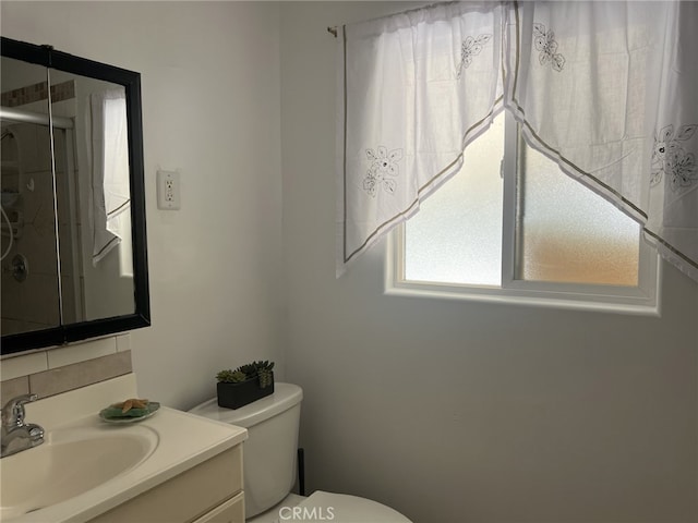 bathroom with vanity, toilet, and an enclosed shower