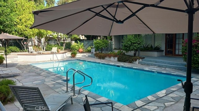 view of pool with french doors and a patio area