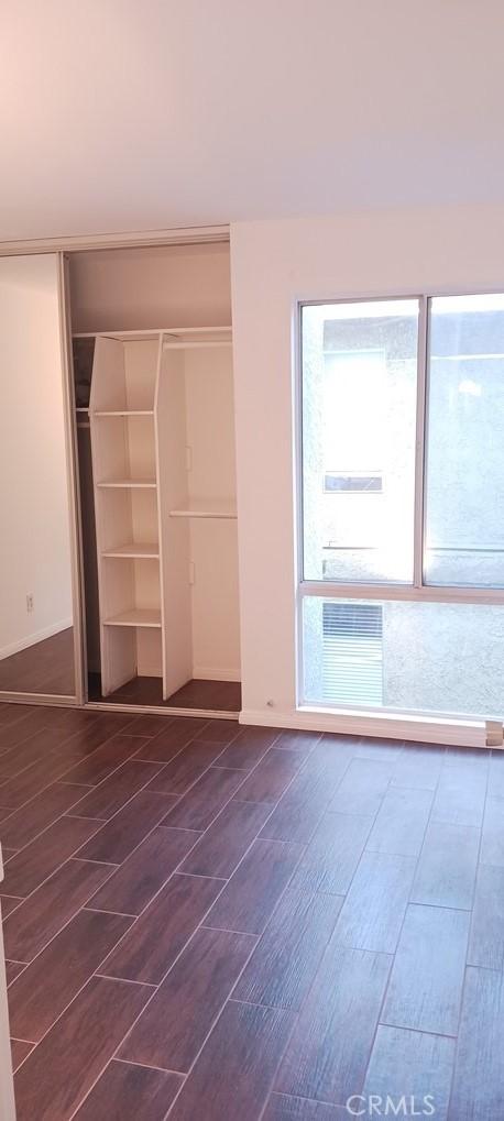 unfurnished bedroom featuring dark wood-type flooring and a closet