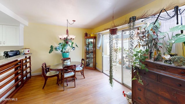 dining area featuring light wood-type flooring and a notable chandelier